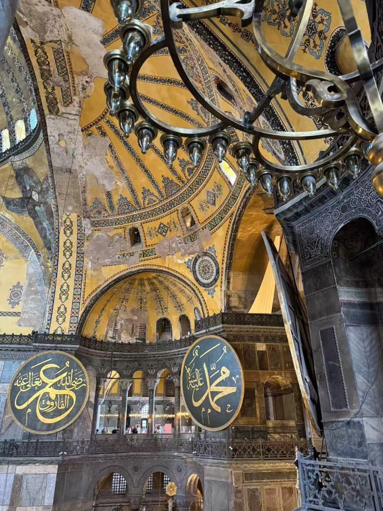 Interior of Hagia Sophia with golden mosaics, domes, and large Arabic calligraphic roundels, Istanbul, Turkey