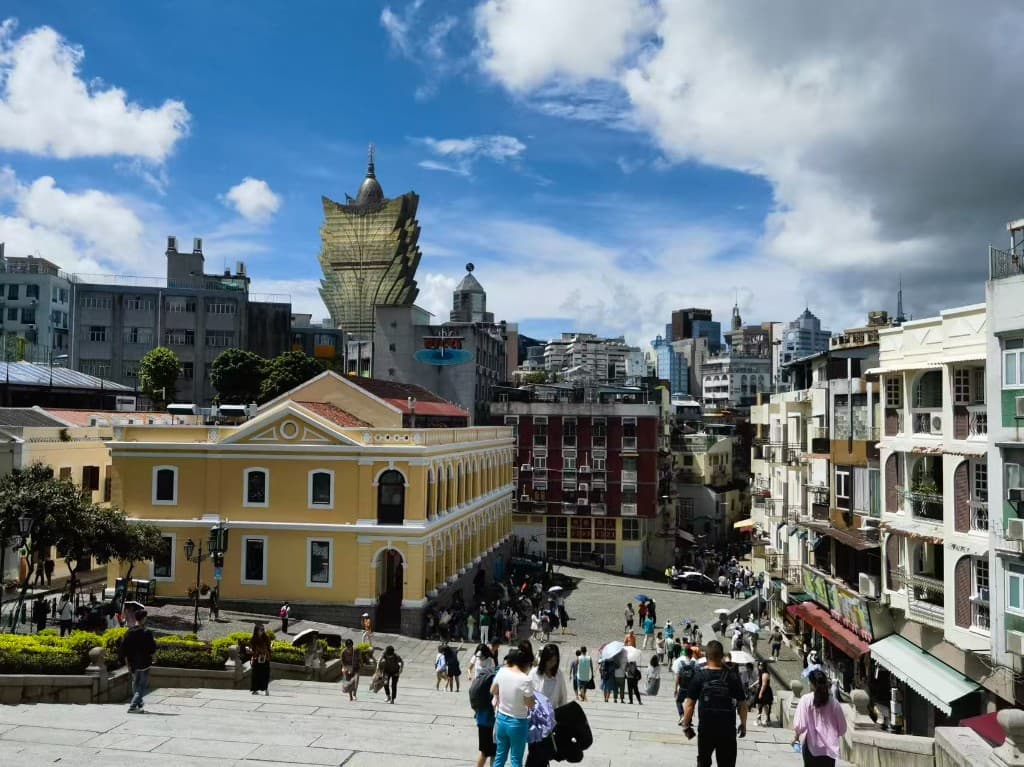 Stone steps above a busy plaza with colonial buildings and the Grand Lisboa tower, Macau, China